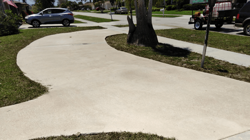 A car is parked on the side of the road in a driveway.