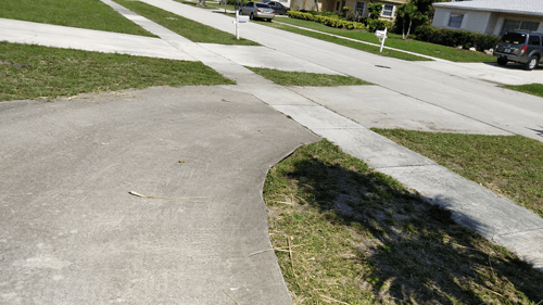 A car is parked on the side of the road next to a sidewalk.