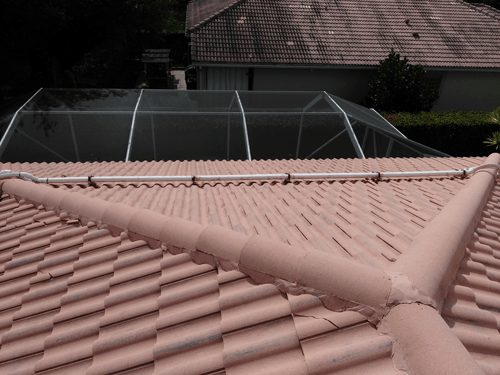 The roof of a house with a swimming pool in the background