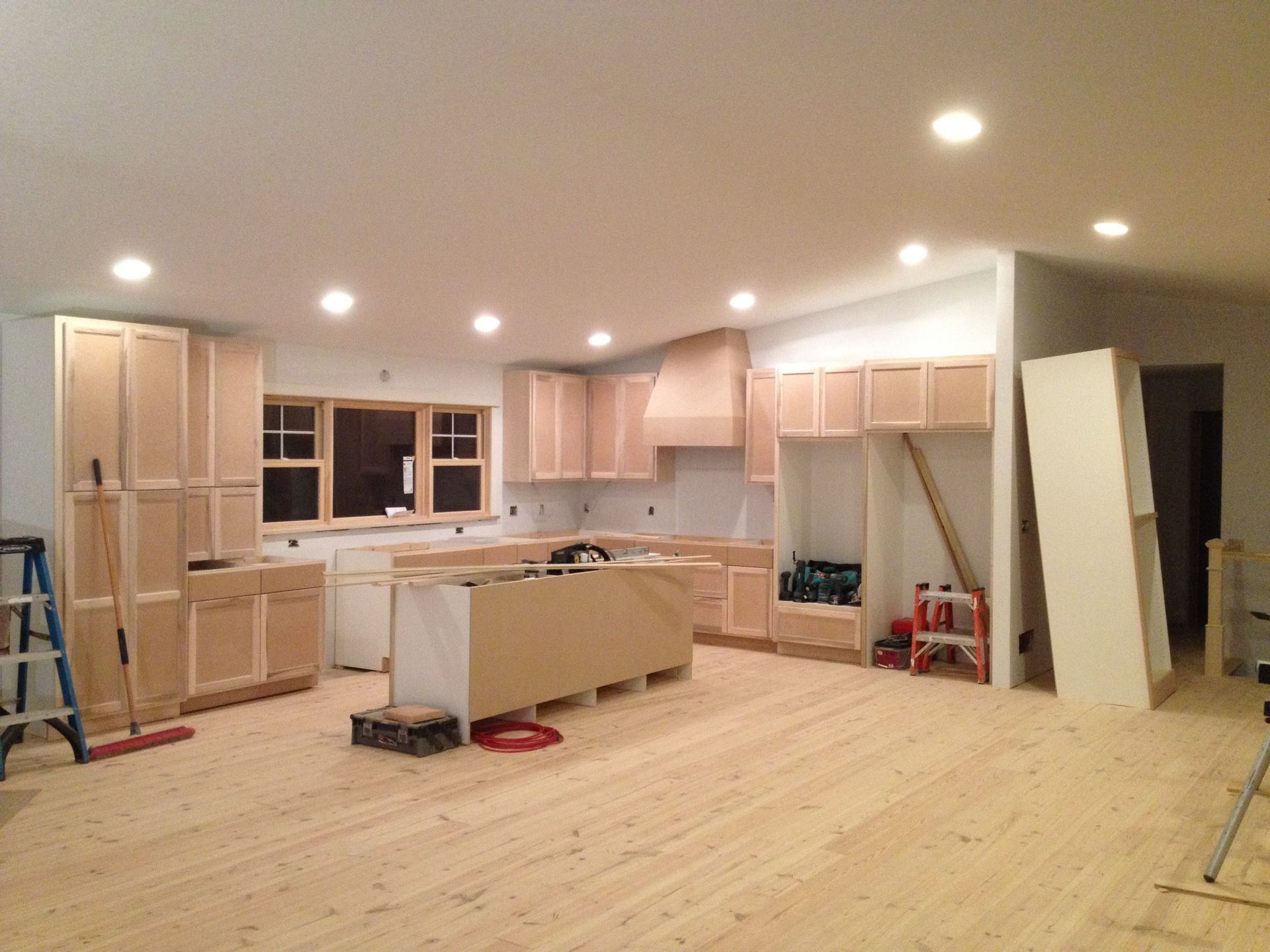 A kitchen under construction with wooden floors and cabinets