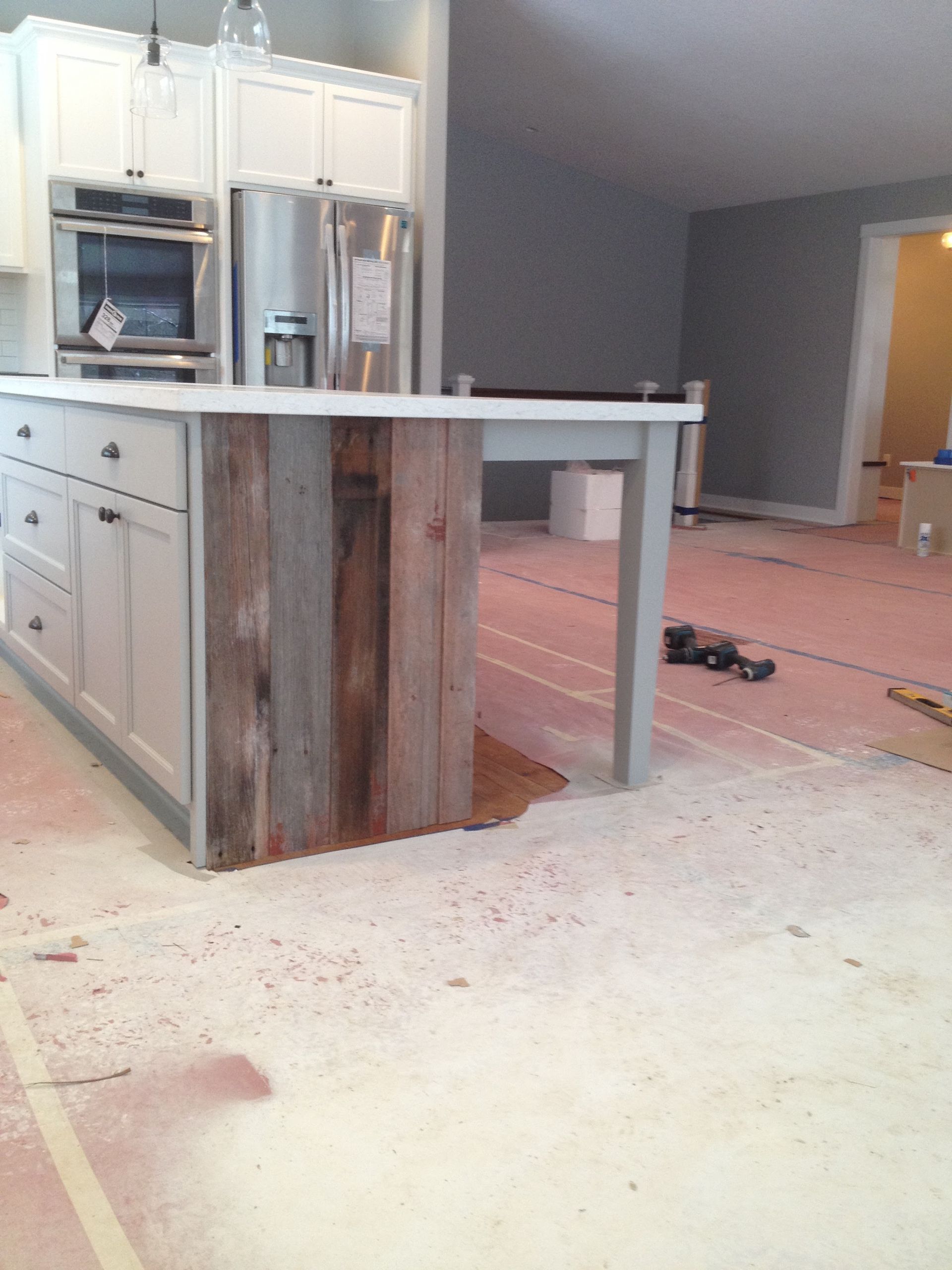 A kitchen under construction with a wooden island in the middle