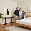 Familia posando en un dormitorio luminoso junto a una cama, un espejo y una mesa consola.