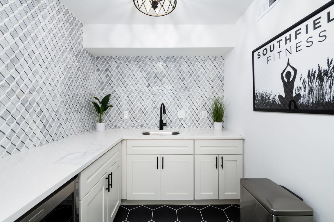A kitchen with white cabinets and a sign that says southfiel fitness