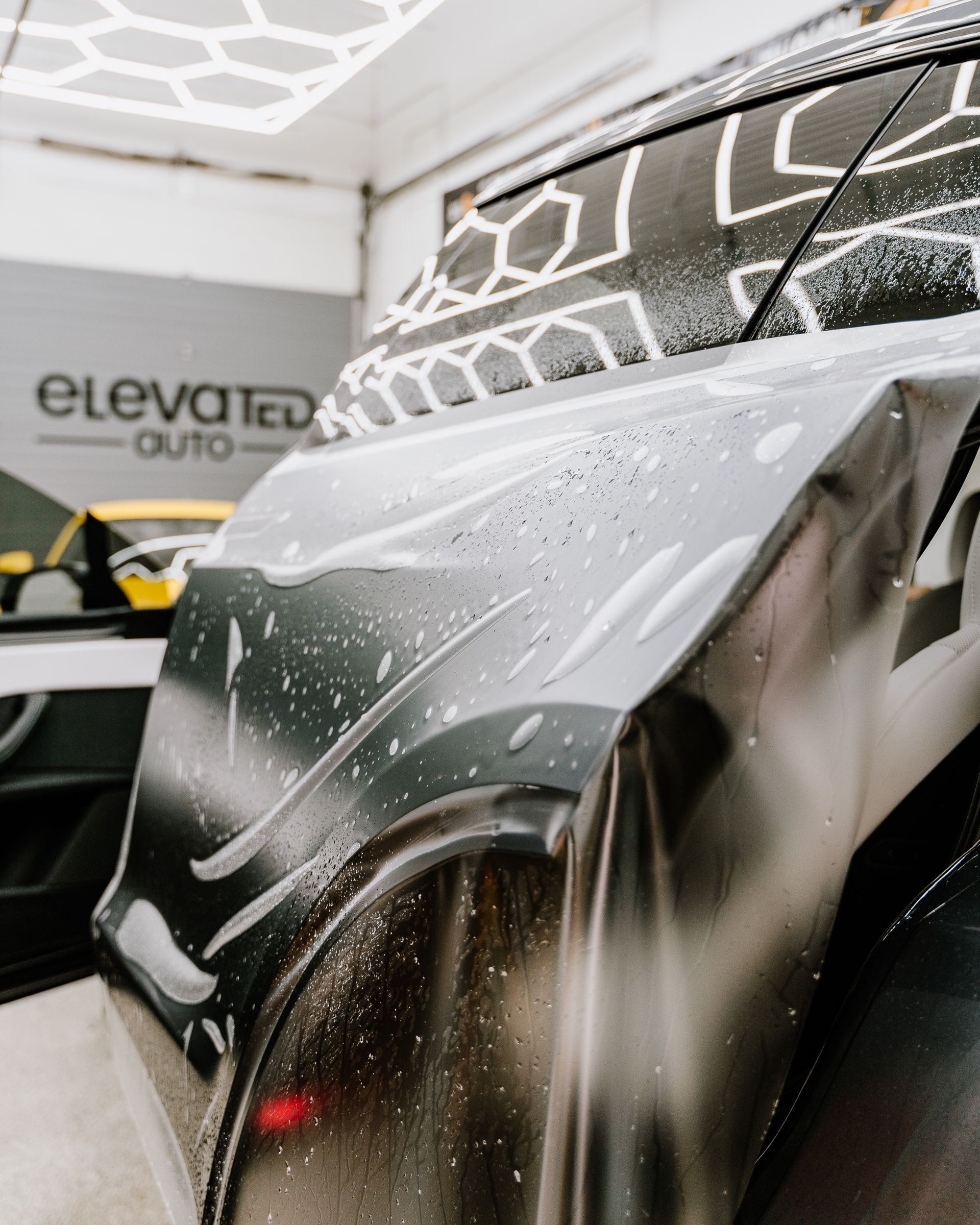 A close up of a car being cleaned in a garage.