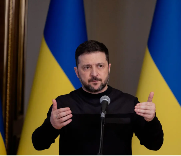Crowd waving blue-and-yellow Ukrainian flags in front of a government building