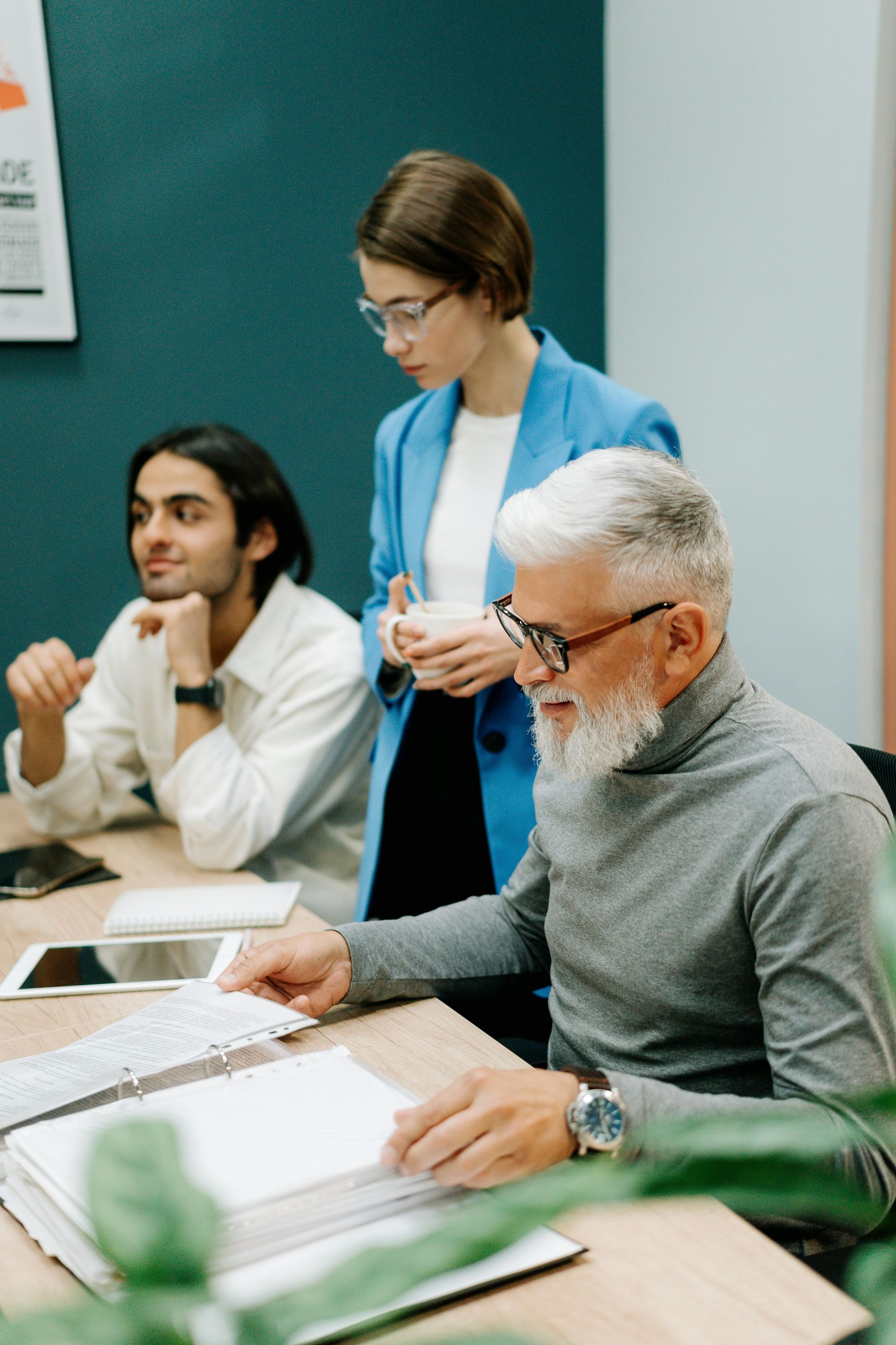 A group of people are sitting at a table having a meeting.