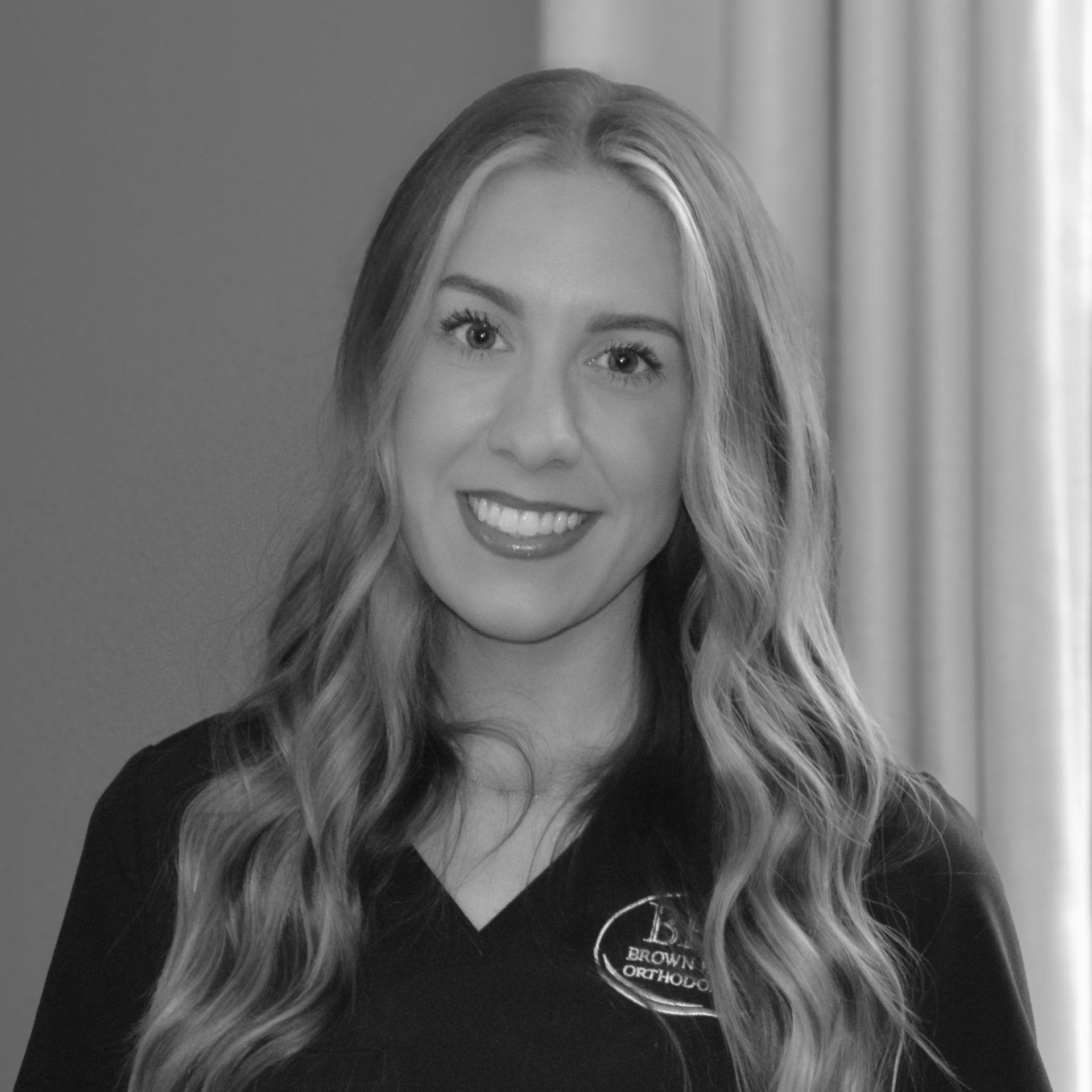 Brittani is an orthodontic assistant and is smiling for the camera.