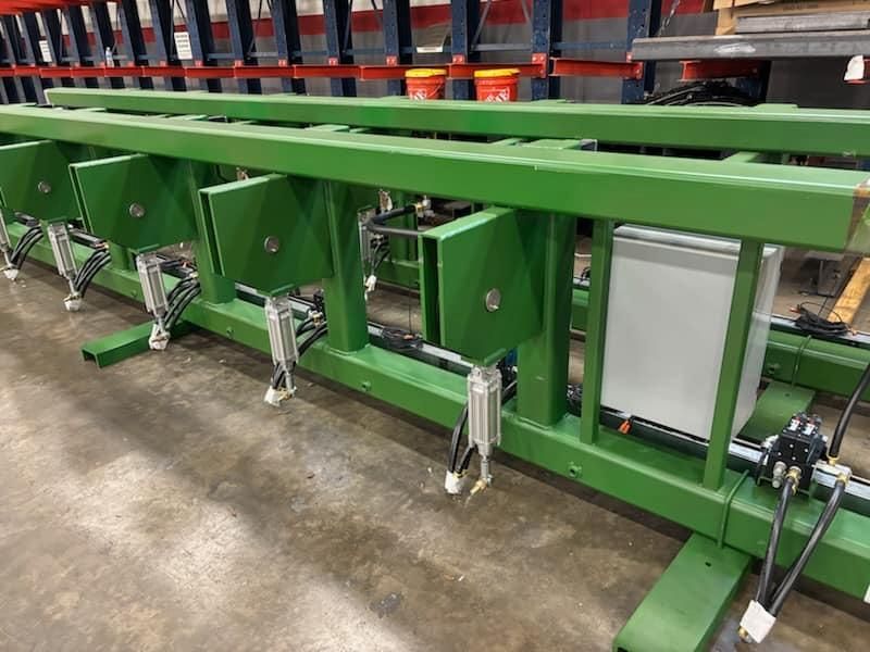 Green metal industrial assembly with electrical components, likely for a manufacturing process.