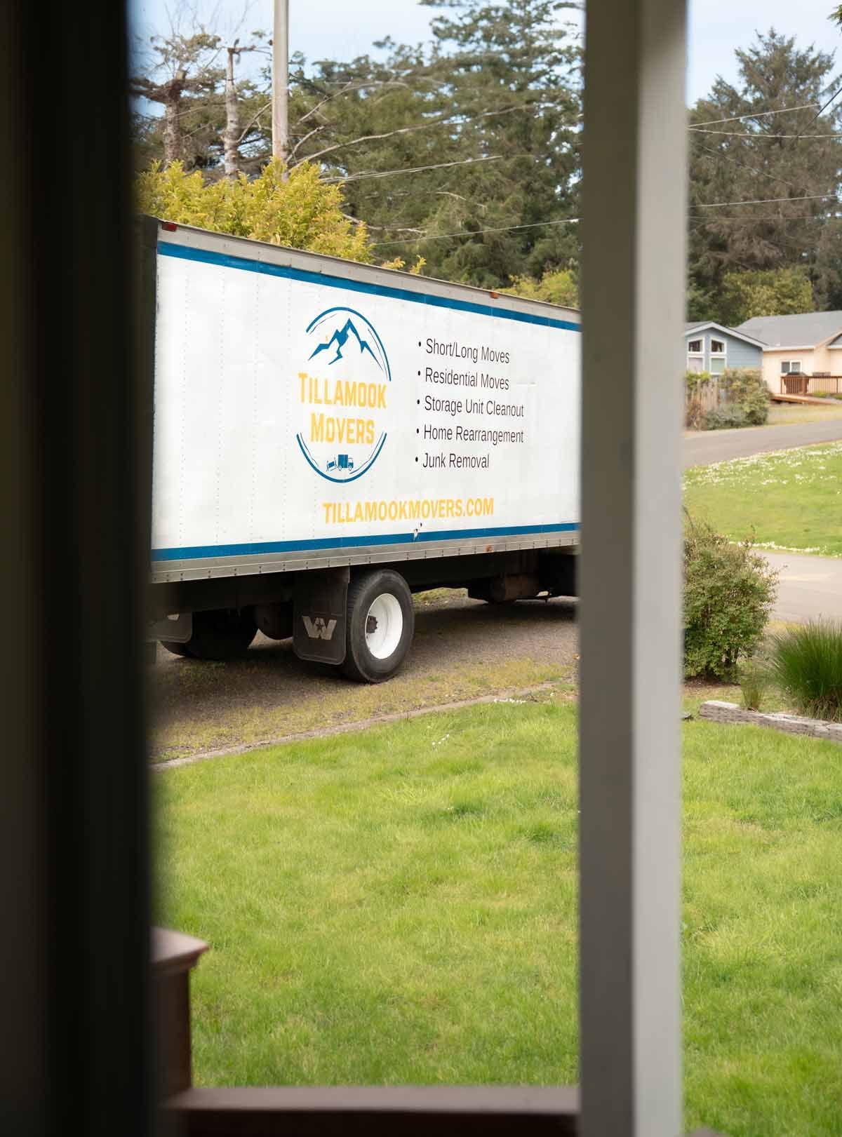 A moving truck is parked in front of a house.