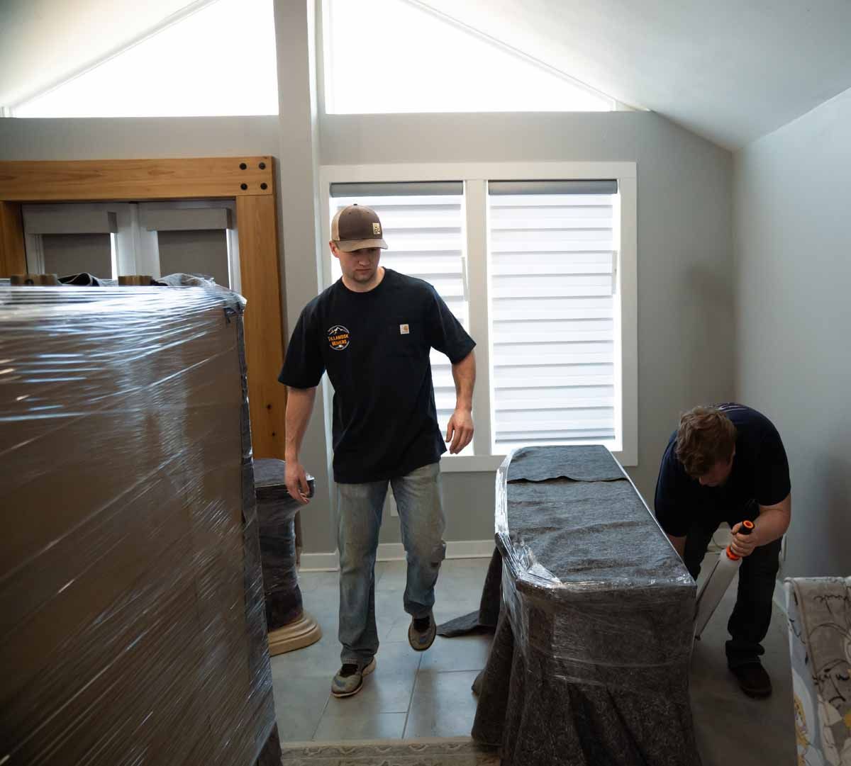 A man in a black shirt is standing next to a table