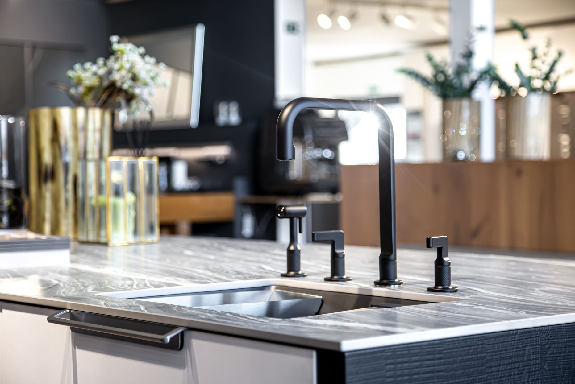 Modern kitchen sink with black faucet on a gray countertop.