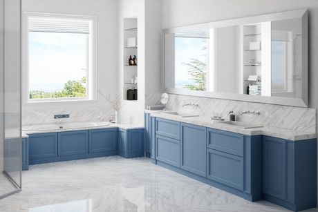 Blue bathroom with marble counters and large mirrors. A window provides natural light.