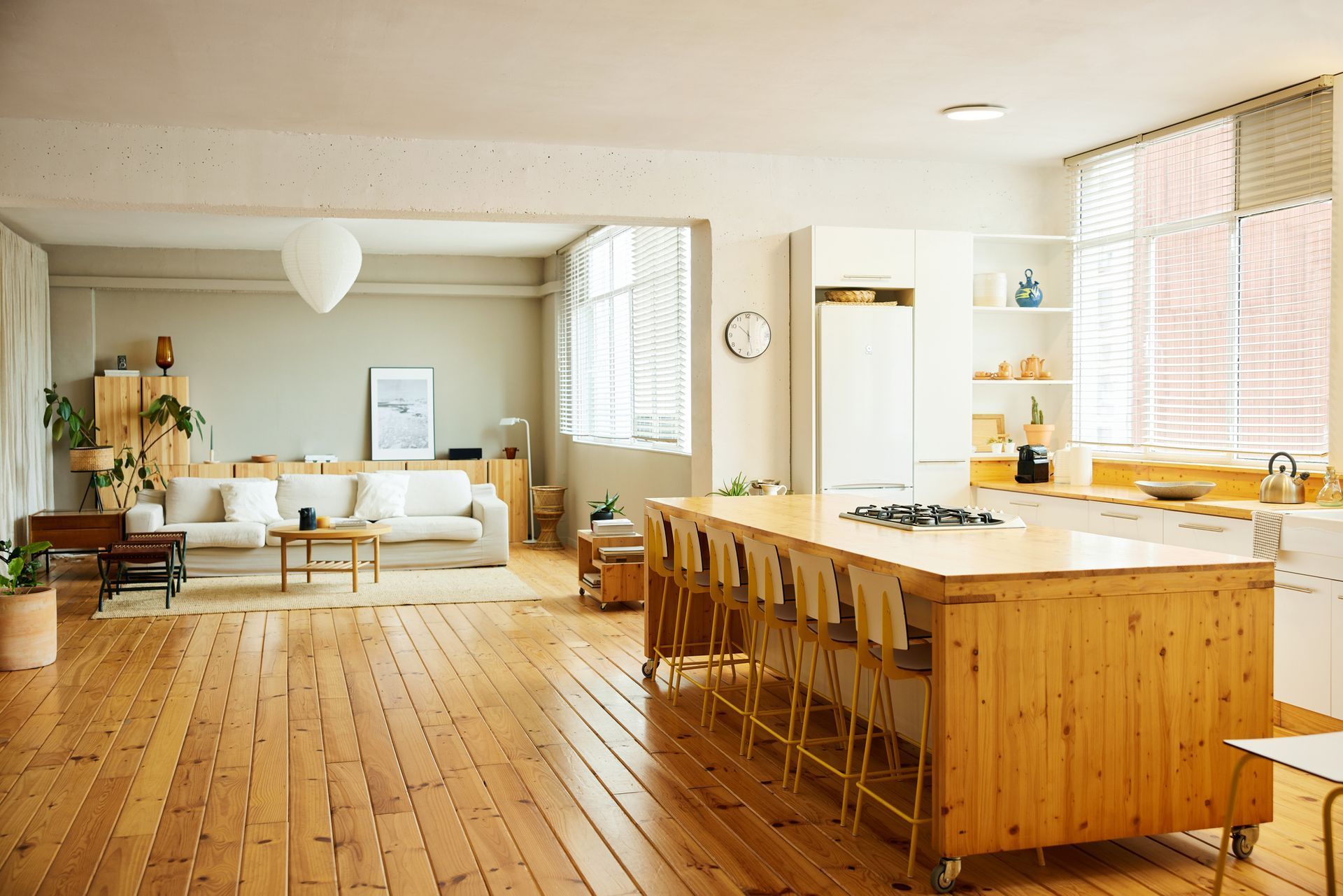Spacious kitchen with a large island, wood floors, and a living area with a sofa.