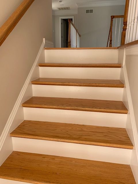 Wooden staircase with white risers and tan treads.