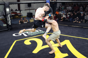 Two men are fighting in a boxing ring with the number 24 painted on the floor