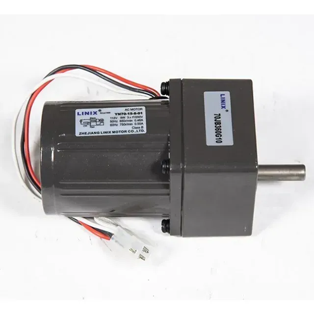 Black electric motor with attached gearbox and protruding silver shaft on white background
