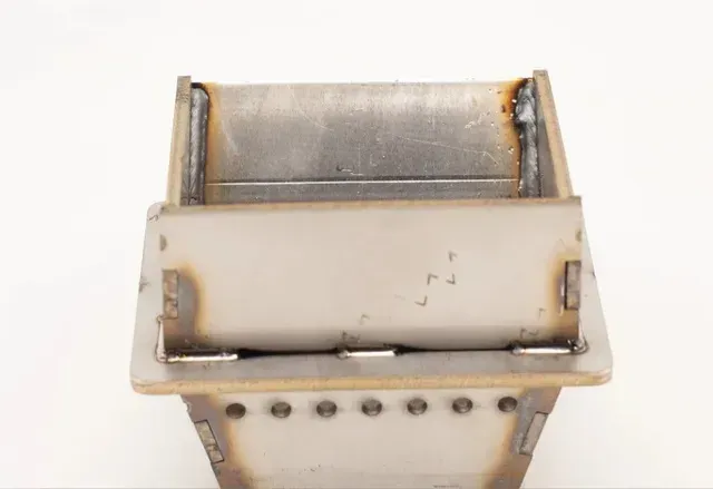 Close-up of a rusted metal mechanical part with a white housing and bolts