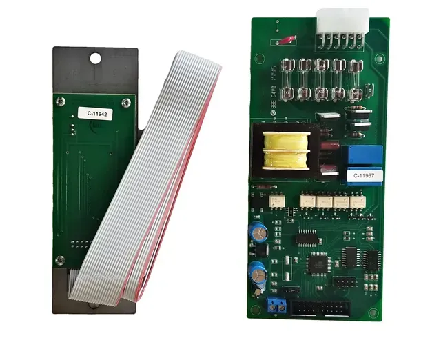 Two green circuit boards with components, one with a gray ribbon cable attached