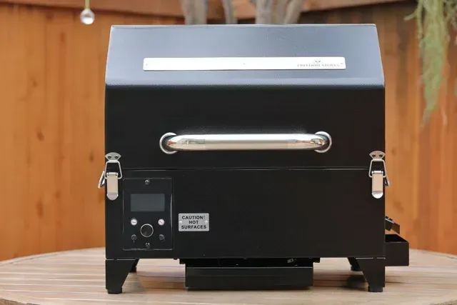 Black countertop appliance with silver handle and top slot on a wooden surface