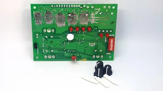 Green circuit board with red LEDs and a black component, plus two loose capacitors and a resistor beside it