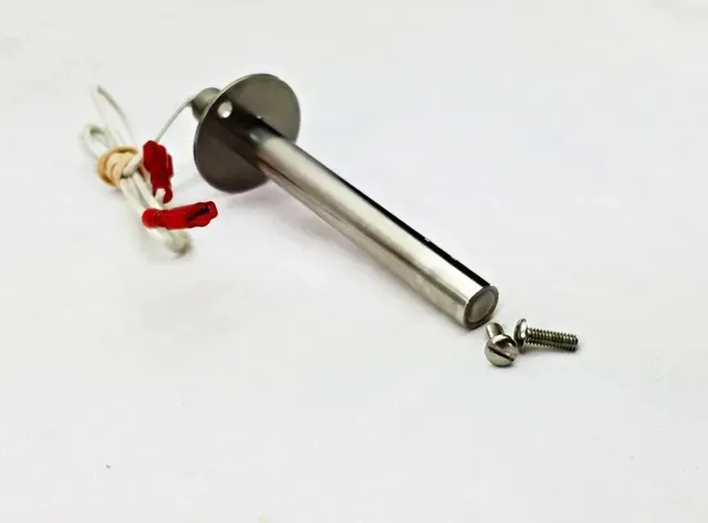Chrome door latch with small red-and-white keychain and a loose screw on a white background