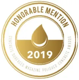 Gold “Honorable Mention” award seal with 2019 and “Concrete Surfaces Magazine Polished Concrete” text
