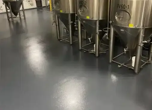 Stainless steel industrial tanks in a clean factory with a polished gray floor