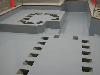 Indoor obstacle course with gray ramps and square cutouts on a smooth floor