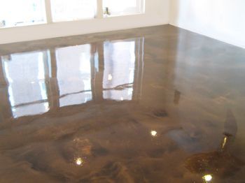 Empty room with glossy brown concrete floor reflecting windows and light