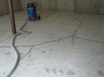 Blue air compressor with hose on a concrete floor in an empty room