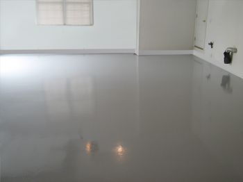 Empty white room with glossy floor and a window on the left.