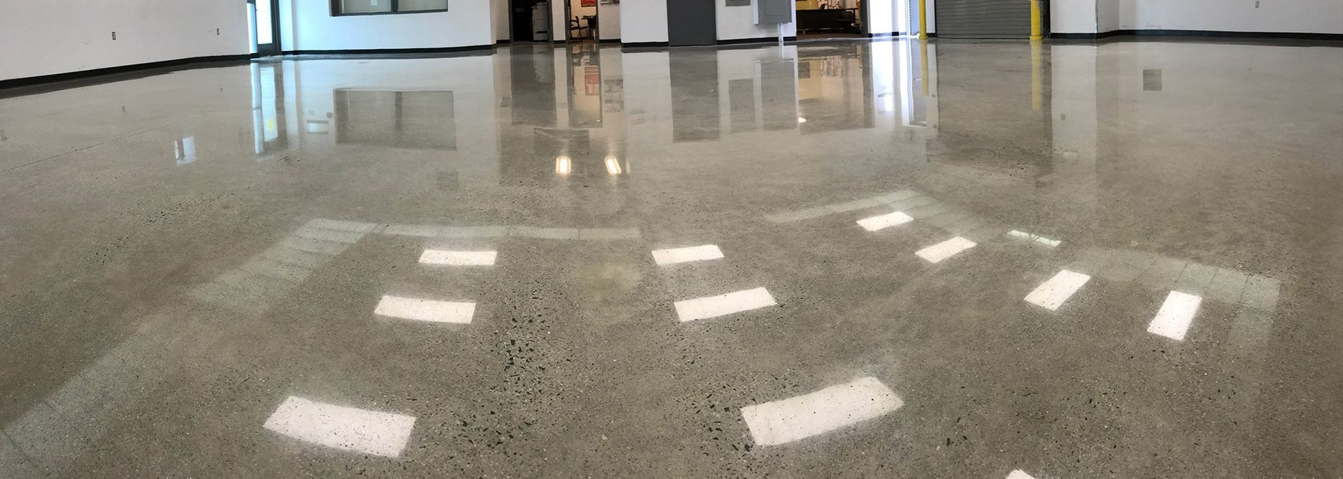 Indoor glossy floor with bright light reflections and a curved pattern of white floor markers