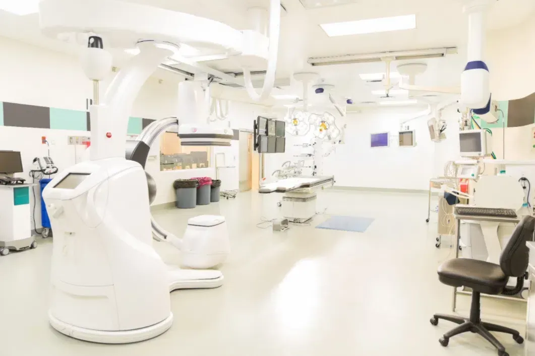 Bright hospital operating room with surgical equipment, monitors, and overhead lights