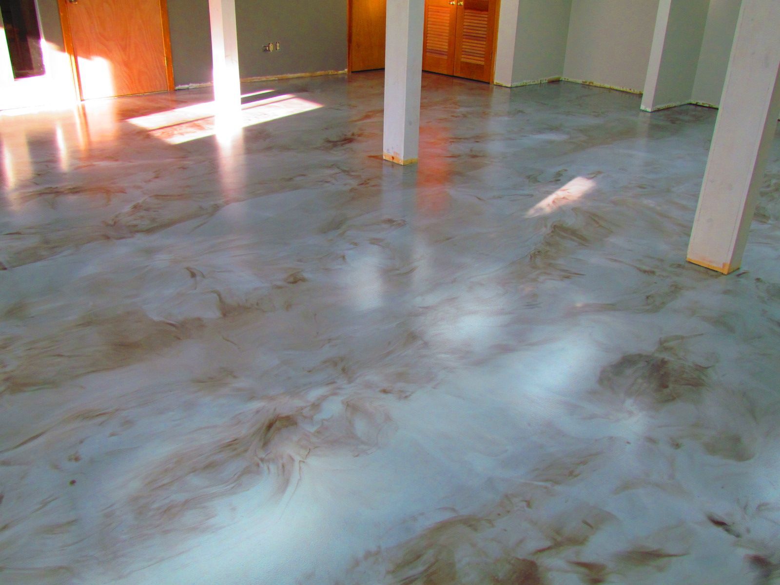 Empty room with glossy white marble floor, sunlit from windows, and a few white columns.