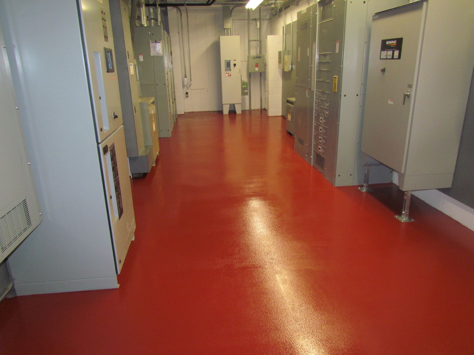 Red-floored industrial hallway with gray electrical cabinets along both sides