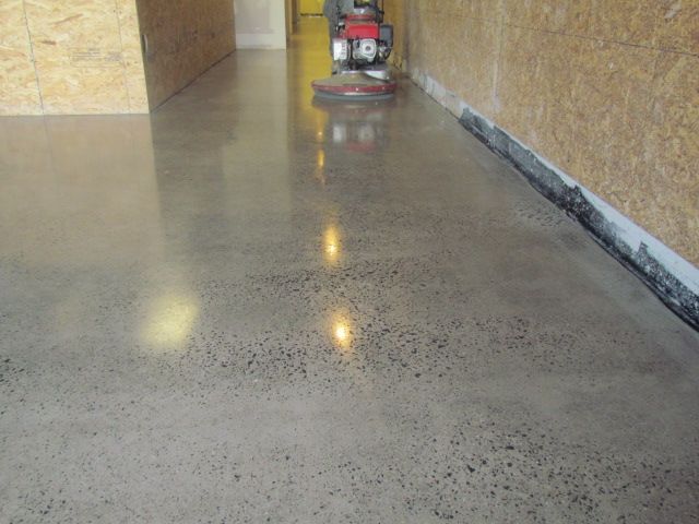 Polished concrete floor in a hallway with a floor buffer at the far end