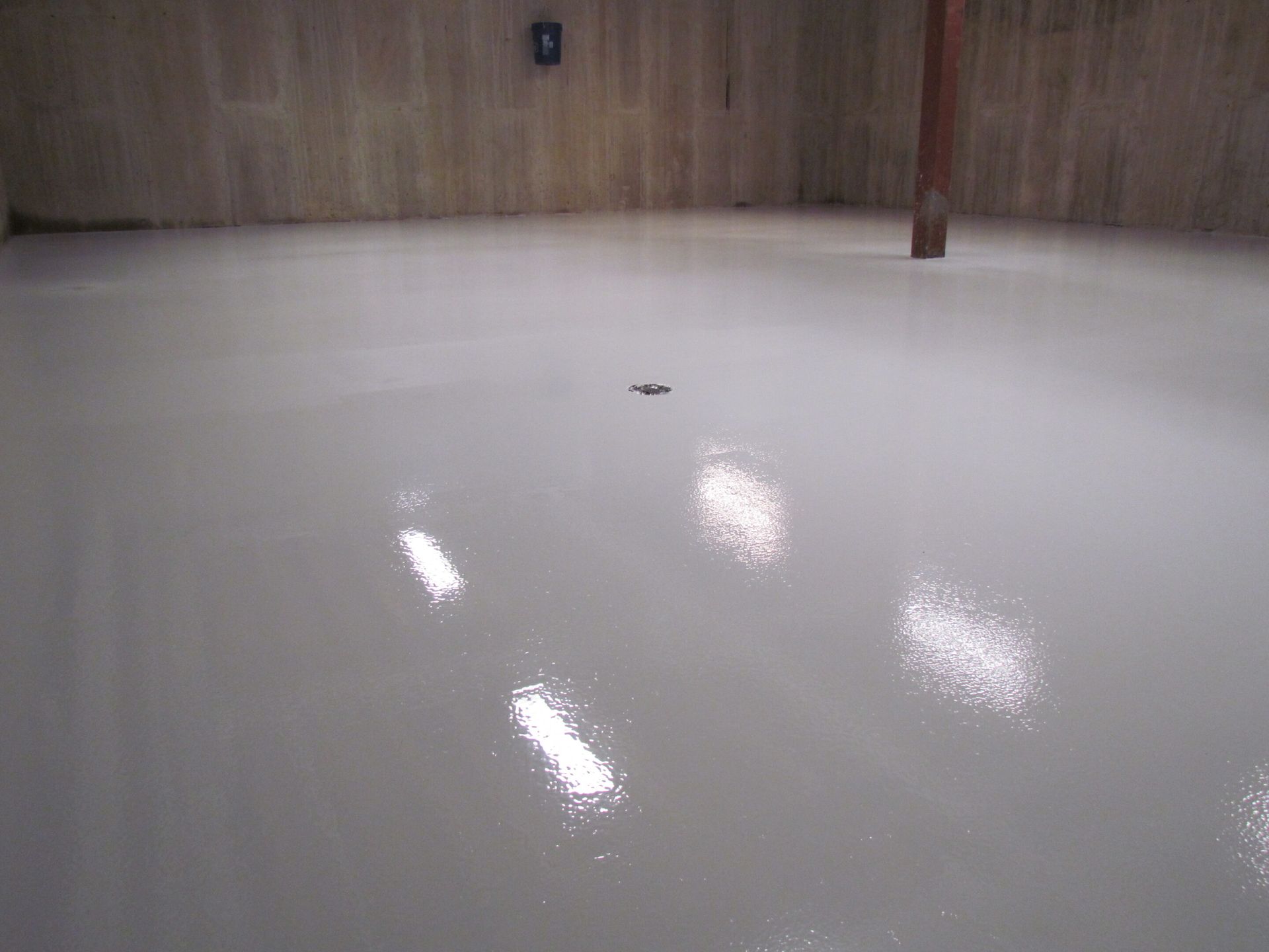 Empty glossy white floor in a wood-paneled room with bright reflections.