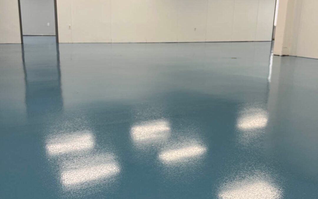 Empty glossy blue floor in a bare room with white walls and reflected ceiling lights