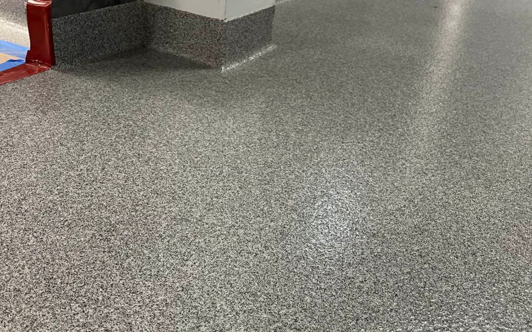 Speckled gray terrazzo floor beside a wall and column in an indoor lobby