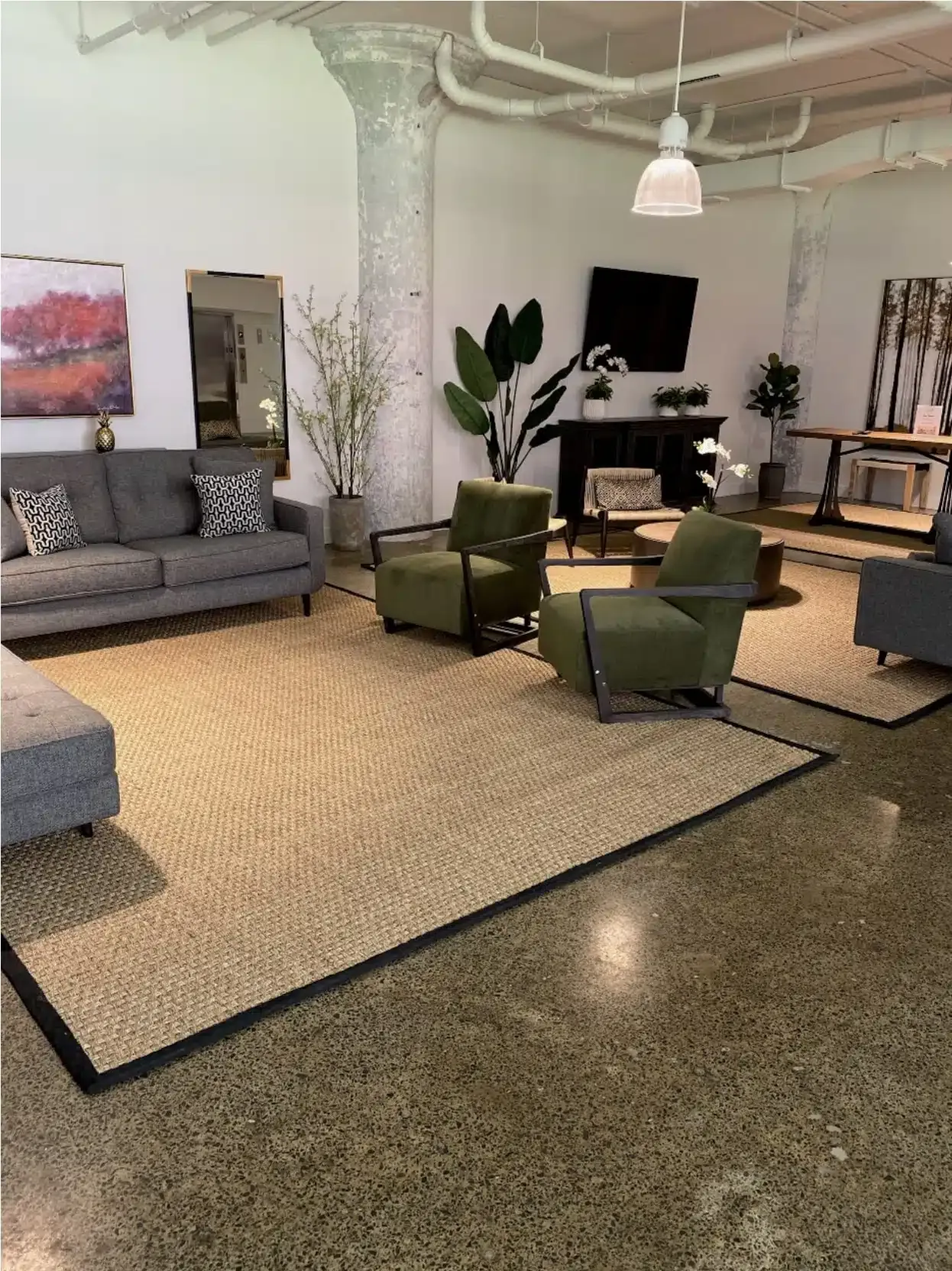 Modern lounge with sofas, green chairs, plants, and a TV in an open showroom-like space