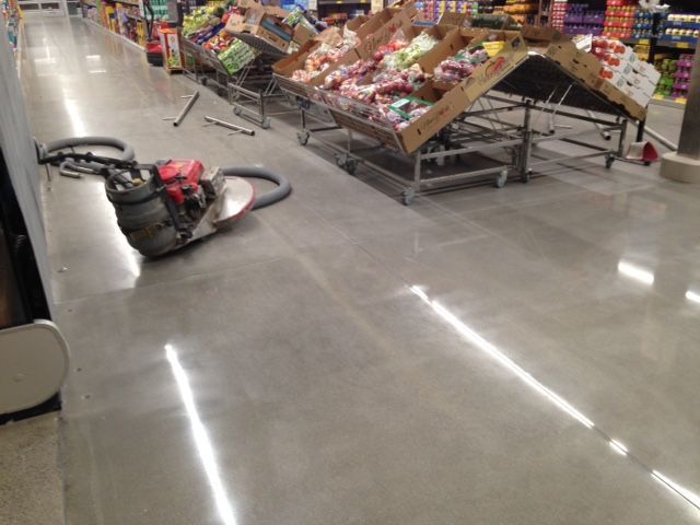Vacuum cleaner on polished store floor beside candy display carts