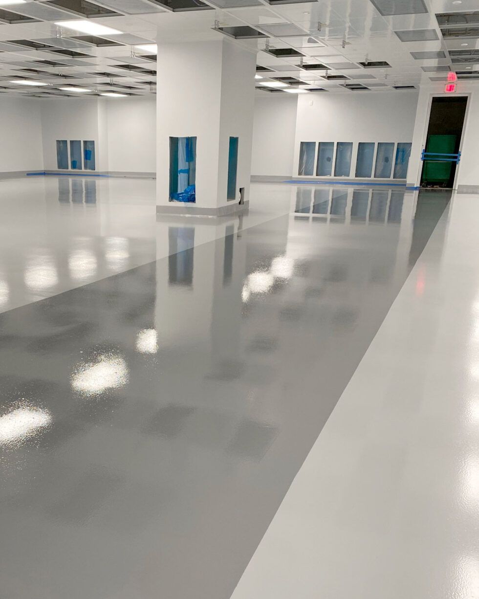 Empty glossy room with white pillars, blue lockers, and a red EXIT sign.