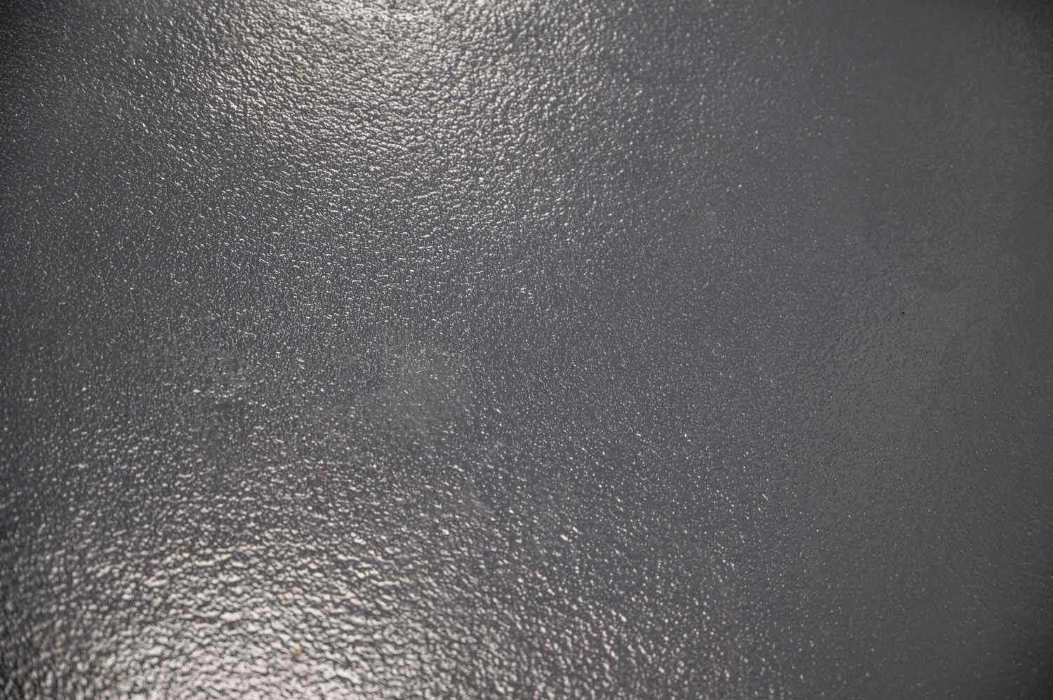 Close-up of a gray, textured surface with light reflections