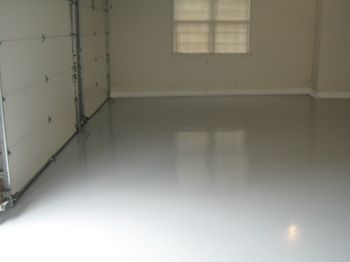 Empty white garage with glossy floor and a small window at the back