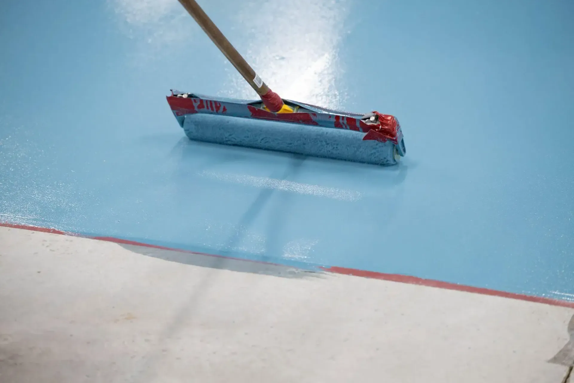 Toy boat on a blue floor with a red boundary line nearby