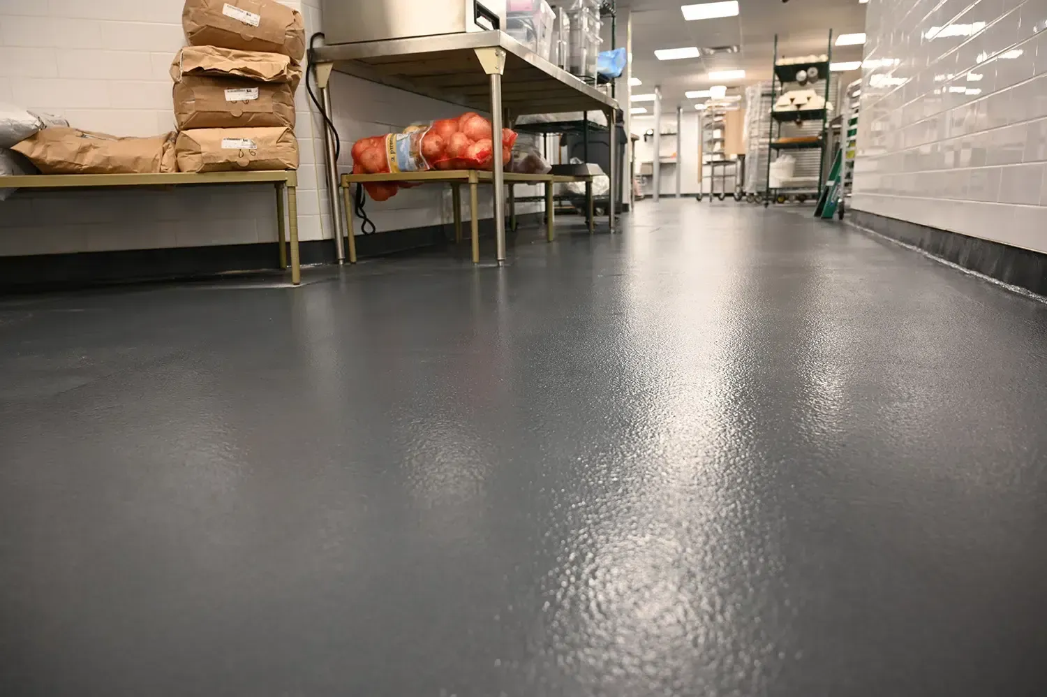 Low-angle view of a clean warehouse aisle with metal shelving and bags stored along the sides