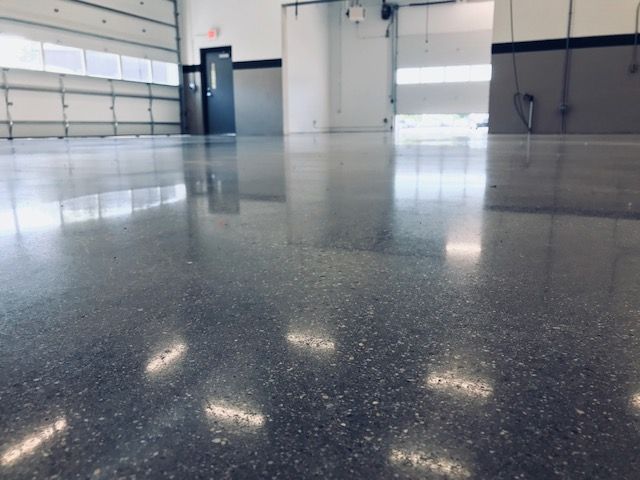 Empty glossy garage interior with white walls, blue door, and reflections on the floor