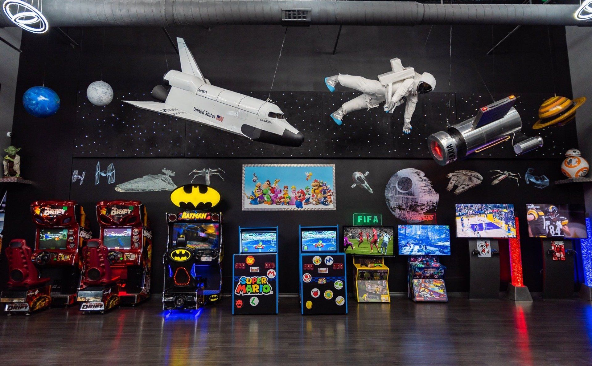 A bunch of arcade games are lined up in a room.