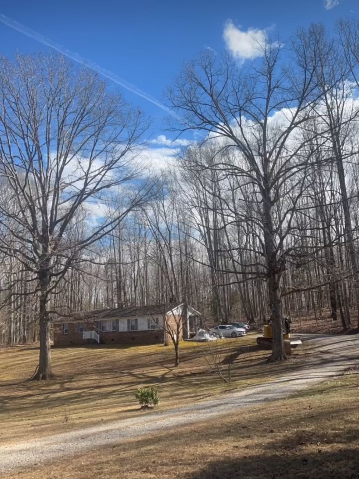 A house in the middle of a field with trees in the background.