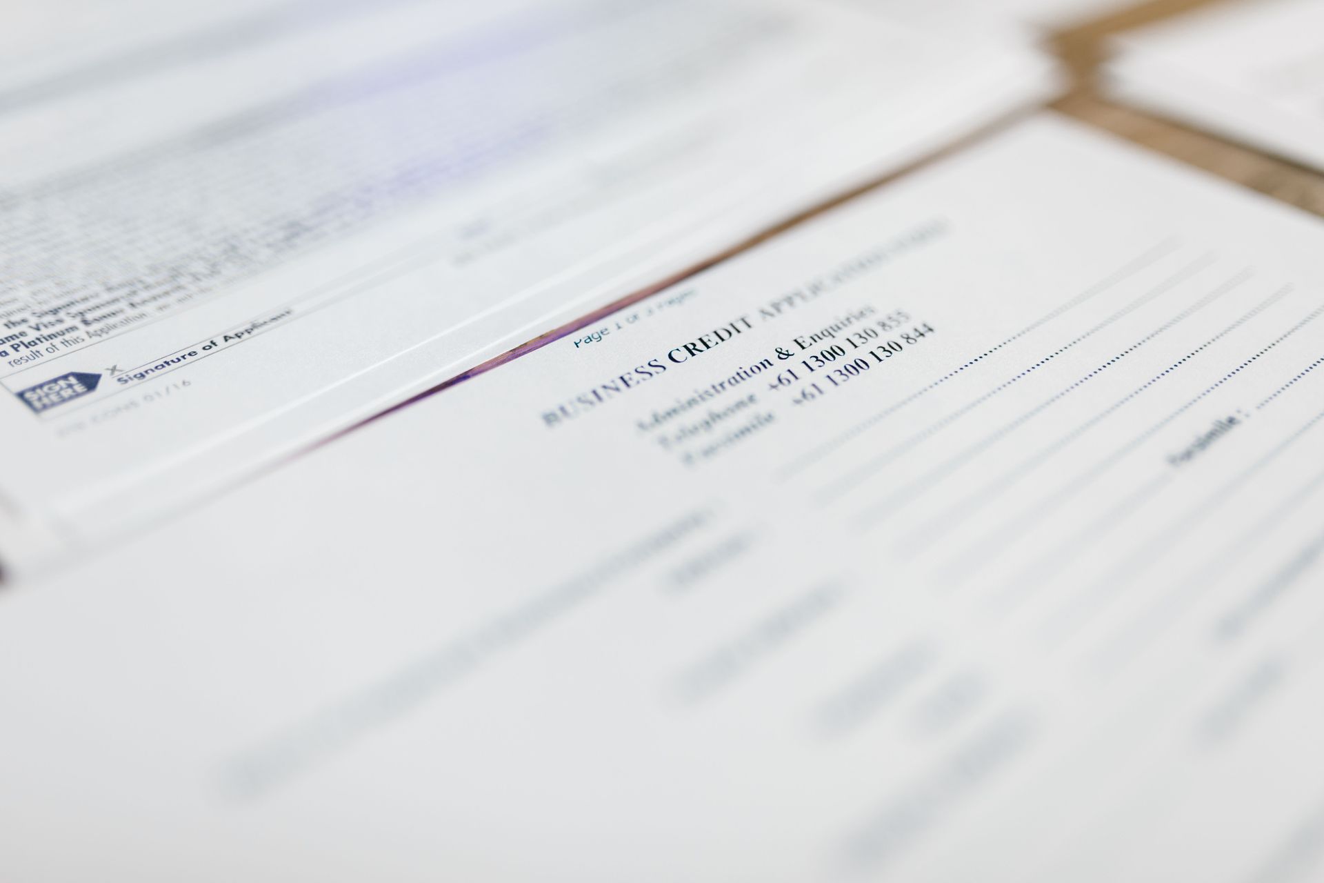 Blurred close-up of a white financial document with black text and blue lines on a desk